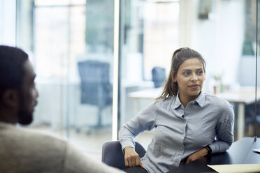 Male and female business colleagues listening in meeting at board room - CAVF60257