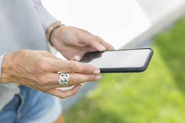 Woman's hands holding smartphone, close-up - JUNF01599