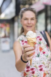 Woman's hand holding ice cream cone, close-up - JUNF01634