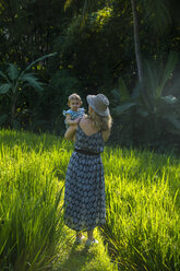 Indonesien, Bali, Ubud, Frau mit ihrem kleinen Mädchen in den Reisfeldern - RUNF00400