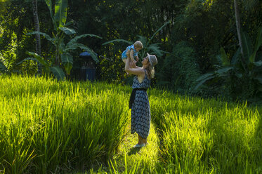 Indonesien, Bali, Ubud, Frau mit ihrem kleinen Mädchen in den Reisfeldern - RUNF00401