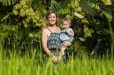 Indonesien, Bali, Ubud, Frau mit ihrem kleinen Mädchen in den Reisfeldern - RUNF00402