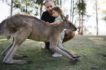 Australien, Brisbane, Vater und kleine Tochter streicheln zahmes Känguru - GEMF02672