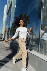 Young casual businesswoman using smartphone in the city - BOYF01243