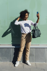 Junge lässige Geschäftsfrau, die in der Stadt ein Smartphone benutzt, Selfie - BOYF01244