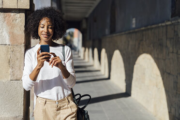 Young casual businesswoman using smartpone in the city - BOYF01250