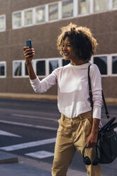 Young casual businesswoman using smartphone in the city - BOYF01260