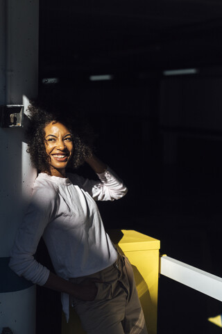 Junge Geschäftsfrau auf einem Parkplatz, Sonnenlicht und Schatten, lizenzfreies Stockfoto