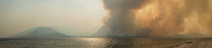Panoramablick auf Rauch, der während eines Waldbrandes im Grand Teton National Park aus den Bergen aufsteigt - CAVF60356