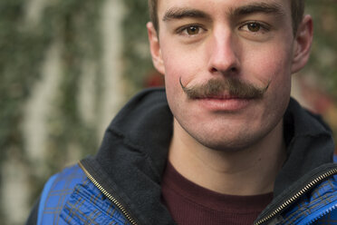 Close-up portrait of confident man with mustache at backyard - CAVF60395