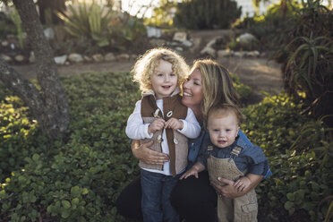 Mother with sons crouching at park - CAVF60402