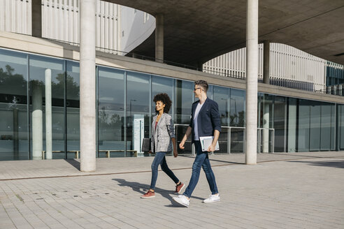 Two colleagues walking outside office building - JRFF02185