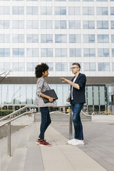 Two colleagues talking outside office building - JRFF02226