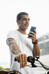 Young man with bicycle and cell phone on the go - ERRF00395