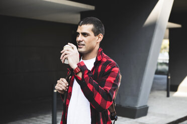 Young man with takeaway coffee in the city on the go - ERRF00398