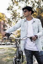 Junger Mann mit Fahrrad und Hut unterwegs - ERRF00414