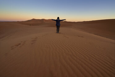 Morocco, back view of woman sitting on desert dune at twilight - EPF00507