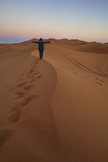 Marokko, Rückenansicht einer auf einer Wüstendüne stehenden Frau in der Dämmerung - EPF00508