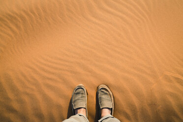 Low section of man standing on sand at Merzouga desert - CAVF60510