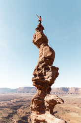 Niedriger Blickwinkel auf eine Wanderin, die auf einer Felsformation steht, gegen einen klaren Himmel an einem sonnigen Tag - CAVF60529