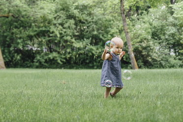 Baby-Mädchen in voller Länge auf einem Feld stehend - CAVF60543