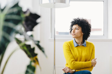 Thoughtful businesswoman wearing sweater while looking away in office - CAVF60563