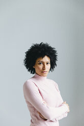 Portrait of confident businesswoman with arms crossed standing against wall in office - CAVF60581