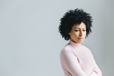 Thoughtful businesswoman standing against wall in office - CAVF60582