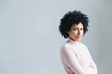 Portrait of confident businesswoman with arms crossed against wall in office - CAVF60583