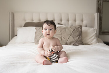 In voller Länge der niedlichen shirtless Baby Junge mit Stofftier sitzt auf dem Bett zu Hause - CAVF60614