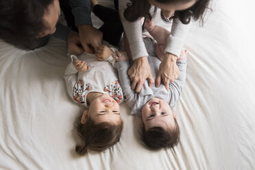 Hohe Winkel Ansicht der spielerischen Eltern kitzeln Kinder auf dem Bett zu Hause - CAVF60615