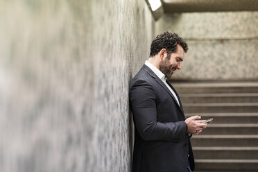 UK, London, Geschäftsmann schaut auf sein Telefon - WPEF01189