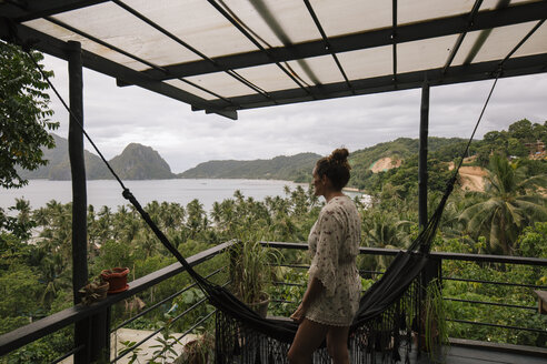 Philippinen, Palawan, El Nido, Frau auf Terrasse mit Hängematte - DAWF00772