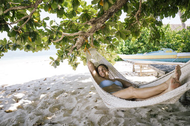 Philippines, Palawan, Mangenguey Island, Busuanga, woman lying in hammock at the beach - DAWF00773