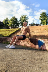 Muskulöser Mann mit nacktem Oberkörper beim Training im Freien - MGOF03863