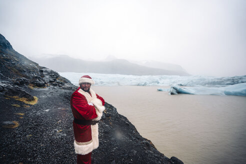 Island, lächelnder Weihnachtsmann vor einem Gletscher - OCMF00175