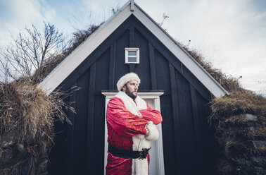 Iceland, Santa Claus standing in front of cabin looking at distance - OCMF00180