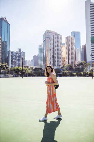 Hongkong, Causeway Bay, Victoria Park, Porträt einer lächelnden Frau auf einem Sportplatz, lizenzfreies Stockfoto