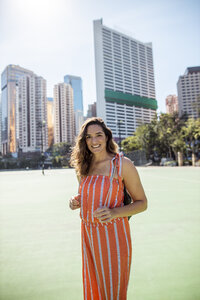 Hong Kong, Causeway Bay, Victoria Park, portrait of smiling woman on a sports field - DAWF00777