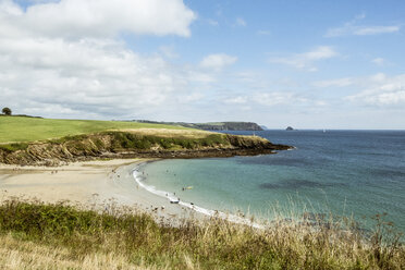 Blick auf einen Sandstrand und Klippen im Sommer, wenige Menschen, klares, flaches Wasser und ruhiges Meer. - MINF09820