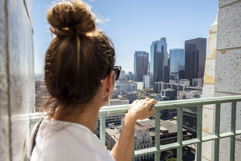 USA, Kalifornien, Los Angeles, Frau schaut von einem Aussichtspunkt auf die Stadt, lizenzfreies Stockfoto