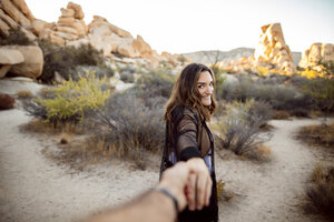 USA, California, Los Angeles, portrait of smiling woman walking hand in hand in Joshua Tree National Park - DAWF00848