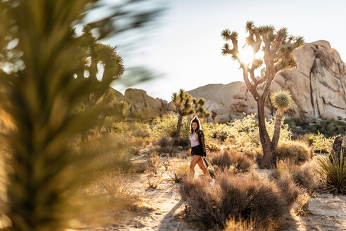 USA, Kalifornien, Los Angeles, Frau beim Spaziergang im Joshua Tree National Park im Gegenlicht - DAWF00853