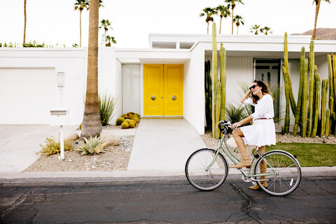 USA, Kalifornien, Palm Springs, Frau auf Fahrrad auf der Straße, lizenzfreies Stockfoto