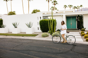 USA, Kalifornien, Palm Springs, Frau auf Fahrrad auf der Straße - DAWF00864