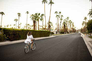 USA, Kalifornien, Palm Springs, Frau fährt Fahrrad auf der Straße - DAWF00868