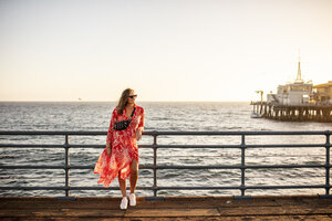 USA, California, Santa Monica, smiling woman standing on the pier - DAWF00874