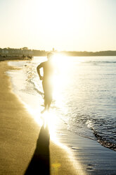 Mann joggt am Strand bei Sonnenuntergang - PUF01352