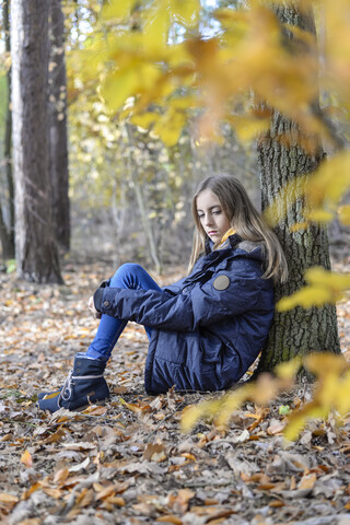 Porträt eines unglücklichen Mädchens im herbstlichen Wald, lizenzfreies Stockfoto