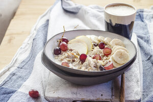 Müslischale mit Bananen, Äpfeln, Trauben, mit Kaffee - SBDF03867